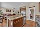 Open kitchen with stainless sink, granite island, and pantry access at 6647 Rego Park Ct, Las Vegas, NV 89166