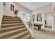Carpeted staircase leading to an open landing near a game room and large windows at 6647 Rego Park Ct, Las Vegas, NV 89166