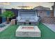 Comfortable outdoor seating with a modern fire pit, surrounded by artificial turf and stylish landscaping at 8136 Canyon Grassland St, Las Vegas, NV 89166