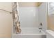 Bright bathroom featuring white tiled shower over tub and window at 8136 Canyon Grassland St, Las Vegas, NV 89166