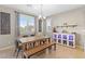 Elegant dining room featuring a modern table and chairs, a bar with custom lighting, and large windows at 8136 Canyon Grassland St, Las Vegas, NV 89166