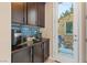 Kitchen area with dark cabinets, granite countertops, and a coffee station with access to the outdoor patio at 8136 Canyon Grassland St, Las Vegas, NV 89166