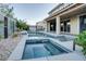 Luxurious backyard oasis with a pool, spa, lush landscaping, and comfortable seating under a covered patio at 8136 Canyon Grassland St, Las Vegas, NV 89166