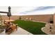 Artificial turf backyard featuring a table, chairs, and stone landscaping at 9526 Granville Bridge St, Las Vegas, NV 89139