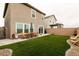 Relaxing backyard featuring artificial turf, patio, wood furniture, and privacy wall at 9526 Granville Bridge St, Las Vegas, NV 89139