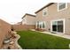 Spacious backyard features artificial grass, patio, wooden seating, and a block wall for privacy at 9526 Granville Bridge St, Las Vegas, NV 89139