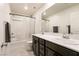 Bathroom features double sink vanity with dark wood cabinets, tiled floors, and shower with a white curtain at 9526 Granville Bridge St, Las Vegas, NV 89139
