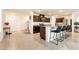 A kitchen showcases an island with seating, dark cabinetry, and seamlessly connects to the entry and stairs at 9526 Granville Bridge St, Las Vegas, NV 89139