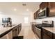 Modern kitchen featuring stainless steel appliances, dark cabinetry, and granite countertops at 9526 Granville Bridge St, Las Vegas, NV 89139