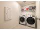 Functional laundry room featuring modern washer and dryer units and built-in storage shelves at 9526 Granville Bridge St, Las Vegas, NV 89139