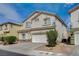 Side view of a two-story home with stucco facade and a two-car garage showcasing desert landscaping at 9732 Kampsville Ave, Las Vegas, NV 89148
