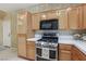 Kitchen featuring stainless steel appliances, wood cabinetry, and white countertops at 9908 Camino Loma Verde Ave, Las Vegas, NV 89117
