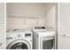 Functional laundry room features modern washer and dryer with shelving at 9908 Camino Loma Verde Ave, Las Vegas, NV 89117