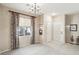Open living room featuring neutral walls, chandelier, and a large window at 9908 Camino Loma Verde Ave, Las Vegas, NV 89117