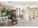 Comfortable living area featuring neutral carpet, interior stairs, and an open concept design at 9908 Camino Loma Verde Ave, Las Vegas, NV 89117
