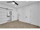 Bright bedroom with a ceiling fan, carpet floors, and doors to the bathroom and closet at 3792 Calle De Rio Ave, Las Vegas, NV 89115