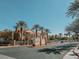 View of the Chateau Nouveau entrance, with its decorative sign, palm trees, and wrought iron gates at 10001 Peace Way # 2269, Las Vegas, NV 89147
