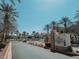 Entrance to Chateau Nouveau, featuring a stone sign, manicured landscaping, and mature palm trees at 10001 Peace Way # 2269, Las Vegas, NV 89147
