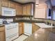 Functional kitchen featuring white appliances and granite countertops with wood finish cabinets at 10001 Peace Way # 2269, Las Vegas, NV 89147