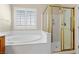 Relaxing bathroom with soaking tub, glass-enclosed shower, and bright window at 10505 Howling Coyote Ave, Las Vegas, NV 89135