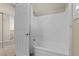 Clean white bathroom featuring a shower-tub combination, sliding glass doors, and neutral wall paint at 10505 Howling Coyote Ave, Las Vegas, NV 89135