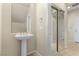 Bathroom features a pedestal sink with tile flooring and mirrored closet doors at 10505 Howling Coyote Ave, Las Vegas, NV 89135
