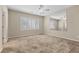 Spacious bedroom featuring a ceiling fan, plush carpet and a mirrored wall at 10505 Howling Coyote Ave, Las Vegas, NV 89135