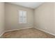 Neutral bedroom with carpet flooring, baseboards, and window at 10505 Howling Coyote Ave, Las Vegas, NV 89135
