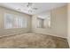 Large bedroom with a ceiling fan, plush carpet, and natural light from the window at 10505 Howling Coyote Ave, Las Vegas, NV 89135