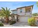Inviting two-story home showcasing a desert landscape, balcony, and welcoming curb appeal at 10505 Howling Coyote Ave, Las Vegas, NV 89135
