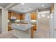 Well-lit kitchen featuring oak cabinets, granite countertops, a large island, and tiled floor at 10505 Howling Coyote Ave, Las Vegas, NV 89135