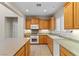 Bright kitchen featuring oak cabinets, granite countertops, a large island, and modern appliances at 10505 Howling Coyote Ave, Las Vegas, NV 89135