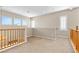 Bright open loft space with carpet flooring, natural lighting, and wood railing at 10505 Howling Coyote Ave, Las Vegas, NV 89135