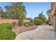 Well-maintained backyard with lush landscaping, walkway, and decorative retaining wall at 10800 Brinkwood Ave, Las Vegas, NV 89134