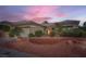 Inviting single-story home with a two-car garage, complemented by desert landscaping and a tiled roof at 10800 Brinkwood Ave, Las Vegas, NV 89134