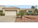 Single story home with a neutral color scheme, well-manicured desert landscaping, and an attached two-car garage at 10800 Brinkwood Ave, Las Vegas, NV 89134