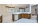Bright eat-in kitchen with white tile flooring, wood cabinets, and modern appliances, great for Gathering meals and entertaining at 10800 Brinkwood Ave, Las Vegas, NV 89134