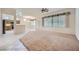 Open-concept living area features carpet flooring with kitchen view at 10800 Brinkwood Ave, Las Vegas, NV 89134