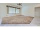 Spacious living room with carpet flooring, bright natural light, and neutral wall color at 10800 Brinkwood Ave, Las Vegas, NV 89134