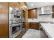 Close-up showcasing stainless steel appliances including double ovens, a wine fridge, and a range hood in the modern kitchen at 1136 Jamesbury Rd, Las Vegas, NV 89135