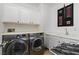 Efficient laundry room features modern washer and dryer, overhead cabinets and sink at 1136 Jamesbury Rd, Las Vegas, NV 89135