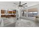 Open-concept living room with backyard views, a modern kitchen, and a ceiling fan at 1136 Jamesbury Rd, Las Vegas, NV 89135