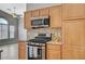 Modern kitchen features stainless steel stove, microwave, and wooden cabinets at 1162 Red Margin Ct # 101, Las Vegas, NV 89183