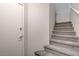 Carpeted staircase with a white door leading to the lower level at 1162 Red Margin Ct # 101, Las Vegas, NV 89183
