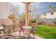 A serene backyard with a small patio, mature trees, and lush green grass, perfect for relaxing at 1163 Regal Lily Way, Las Vegas, NV 89123