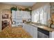 Well-lit kitchen with stainless appliances, granite counters, and white cabinetry with decorative plants on top at 1163 Regal Lily Way, Las Vegas, NV 89123