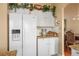 Kitchen with white appliances, cabinetry and granite countertops with a view into the dining area at 1163 Regal Lily Way, Las Vegas, NV 89123