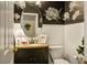 Elegant powder room with floral wallpaper, decorative mirror, pedestal sink, and white toilet at 1163 Regal Lily Way, Las Vegas, NV 89123