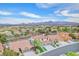 Aerial view showcasing a neighborhood with tree-lined streets and views of distant mountains at 1304 Autumn Wind Way, Henderson, NV 89052