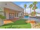 Outdoor view with covered patio, pool, hot tub, and palm trees, creating a relaxing backyard setting at 1304 Autumn Wind Way, Henderson, NV 89052